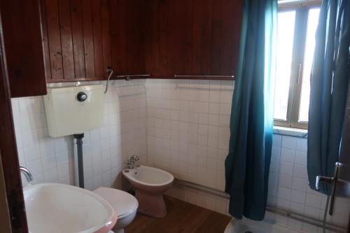 ein Badezimmer mit Waschbecken und Toilette und einem Fenster in der Unterkunft Cosy 3 bedroom house close to the beach in Vila Praia de Âncora