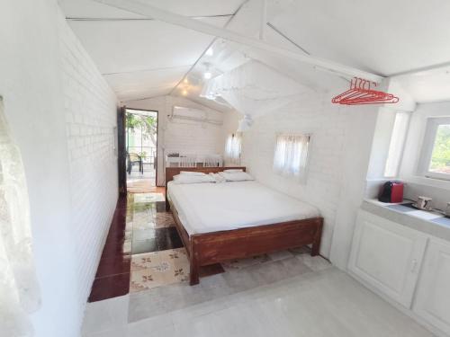 een kleine slaapkamer met een bed en een wastafel bij Syndeo Nest - 400m to Beach in Hikkaduwa