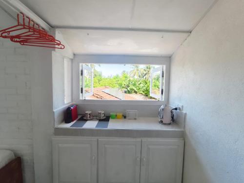 een kleine keuken met een raam in een kamer bij Syndeo Nest - 400m to Beach in Hikkaduwa