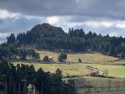 a cross on top of a hill with a field at belle vue in Saint-Sauveur-de-Peyre