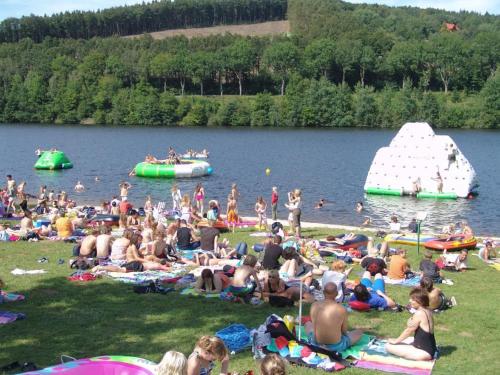 a large crowd of people sitting on the grass at a lake at Nice bungalow in Hallschlag near the lakebeach in Hallschlag