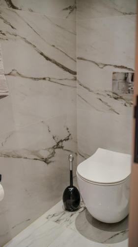 a white toilet in a bathroom with marble walls at GF Luxury Villa with indoor pool -Afytos in Afitos