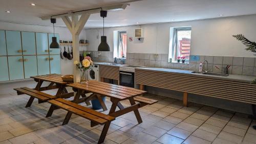 Una cocina con bancos, una mesa y un fregadero. en Ørsted Outdoor, 