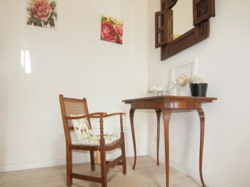 a table and a chair next to a table and a mirror at Very nice cottage with studio on a domain with heated pool in Roussines