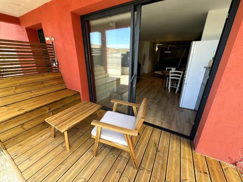 a wooden balcony with a bench and a table at Charmant Studio au calme in Grabels