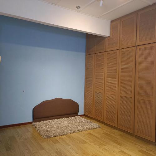 a room with wooden cabinets and a brown chair at Sungai Long Homestay in Kajang