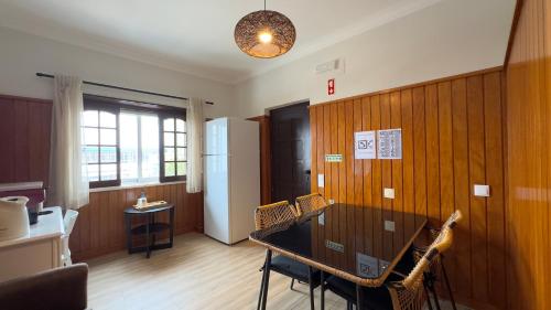 a dining room with a table and a refrigerator at EnSuite 5 Verde Rochedo in Santo Isidoro