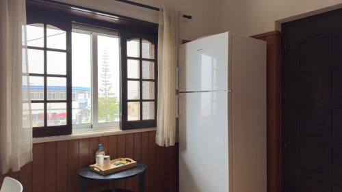 a white refrigerator in a kitchen with a window at EnSuite 5 Verde Rochedo in Santo Isidoro