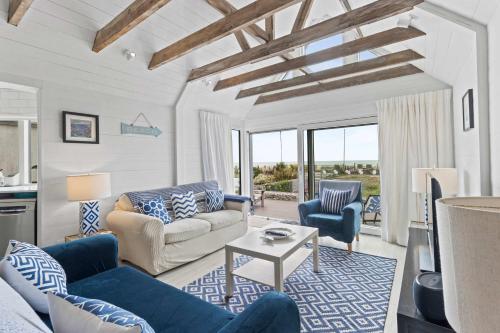 a living room with blue and white furniture at Seashells-Stylish Coastal Living in Pevensey