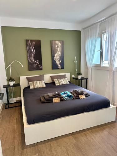 a bedroom with a large bed with two pictures on the wall at Edf. 4 caminos in Nerja