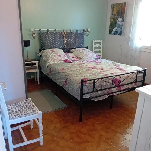 une chambre avec un lit et une chaise dedans dans l'établissement Appartement charmant à Saint-Victor-de-Cessieu - 30 m² - Terrasse, à Saint-Victor-de-Cessieu