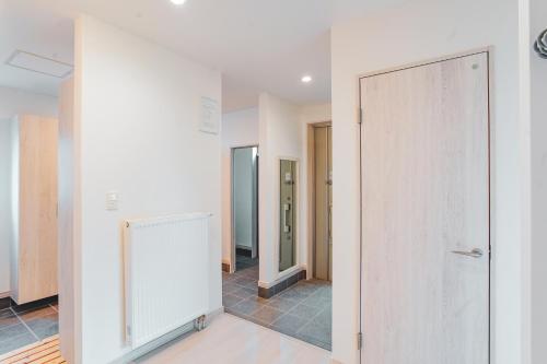an empty corridor with a door in a room at Furano First Tracks - 5mins to ski field in Furano