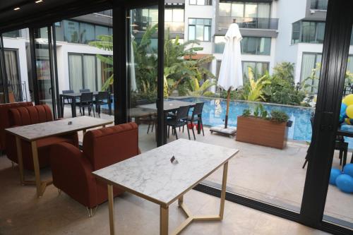 a patio with tables and chairs and a pool at Del Mare Park in Kérynia