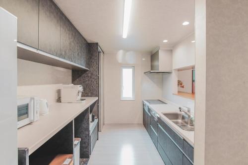 a kitchen with a sink and a counter top at Furano First Tracks - 5mins to ski field in Furano