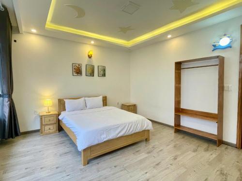a bedroom with a large white bed in a room at AnAn VILLA in Khu Chi Lăng