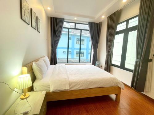 a bedroom with a bed and a large window at AnAn VILLA in Khu Chi Lăng