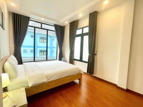 a bedroom with a bed and a large window at AnAn VILLA in Khu Chi Lăng