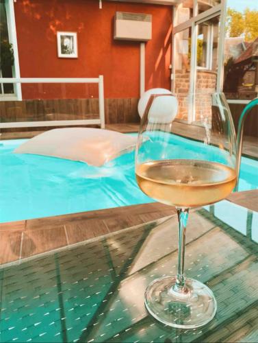 - un verre de vin assis sur une table à côté de la piscine dans l'établissement Maison avec grand jardin, à Aubusson