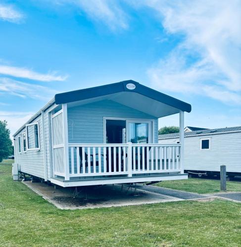 a blue and white mobile home with a porch at BEACH SIDE CARAVAN - haven - Caister on sea in Caister-on-Sea