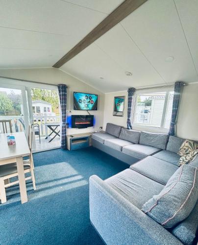 a living room with a couch and a tv at BEACH SIDE CARAVAN - haven - Caister on sea in Caister-on-Sea