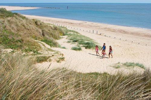 a group of people walking on the beach at BEACH SIDE CARAVAN - haven - Caister on sea in Caister-on-Sea
