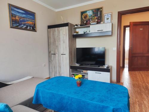 a living room with a blue table and a television at Jacky's Apartament - Апартамент в Свети Влас in Sveti Vlas