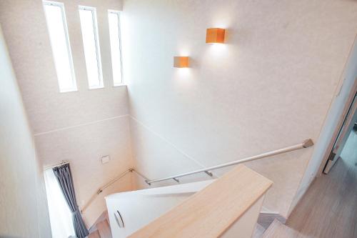 a bathroom with a white toilet and two windows at Furano First Tracks - 5mins to ski field in Furano