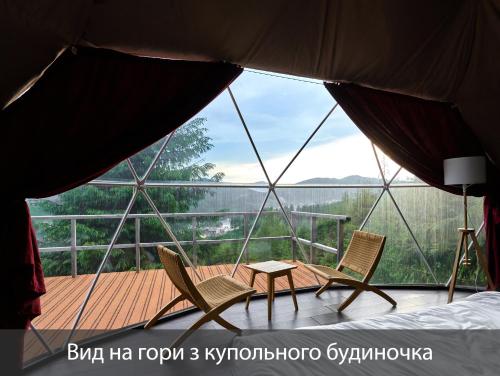 a room with two chairs and a table on a deck at Villas Fomich in Bukovel
