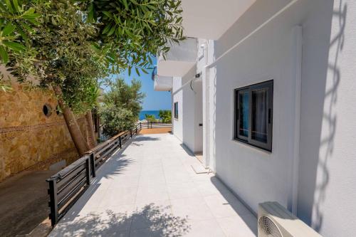 a walkway leading up to a white building with a window at Sunset Aparthotel in Sarandë