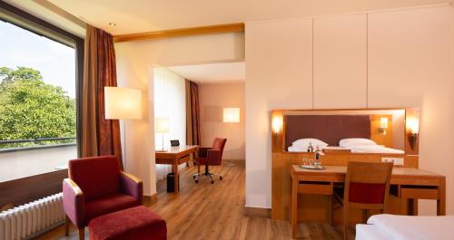 a hotel room with a bed and a table and chairs at Dolce by Wyndham Bad Nauheim in Bad Nauheim