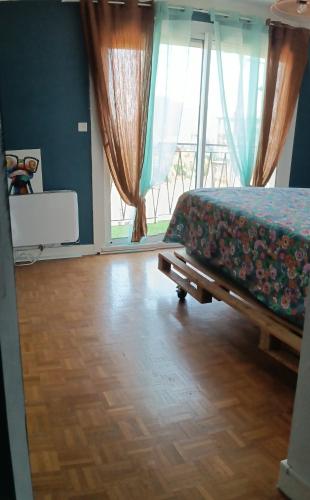 a bedroom with a bed and a large window at Chambre chez moi,chez vous vue sur les vignes in Libourne