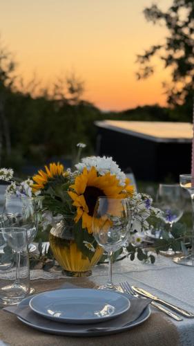 a table with a plate and a vase with sunflowers on it at SM VIP HOUSES in Shanovo