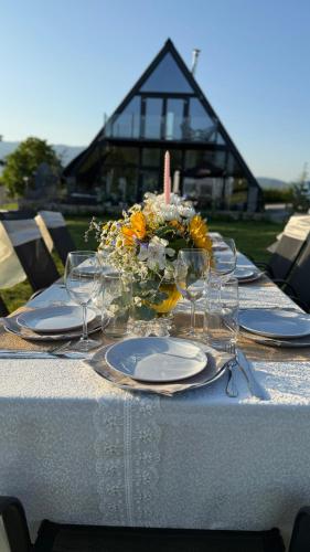 a table with plates and glasses and flowers on it at SM VIP HOUSES in Shanovo