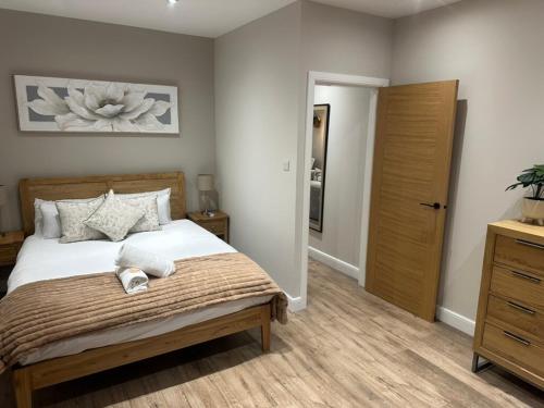 a bedroom with a large bed and a wooden closet at BOFA Snug Apartment in Bridge of Allan