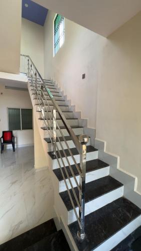 a spiral staircase in a building with a window at GOKUL DELUXE Homestay in Māvalli