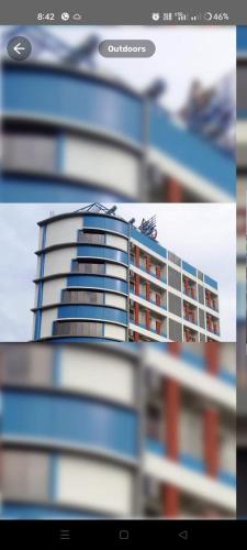 Una imagen de un edificio alto en la distancia. en Hotel Raj Heights, en Solapur