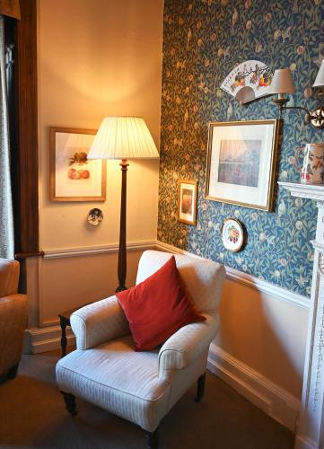 a living room with a chair and a lamp at Orchard Club in Knaresborough