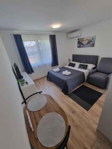 a room with a bed and a table and a couch at Studio Apartment Petra Umag in Umag