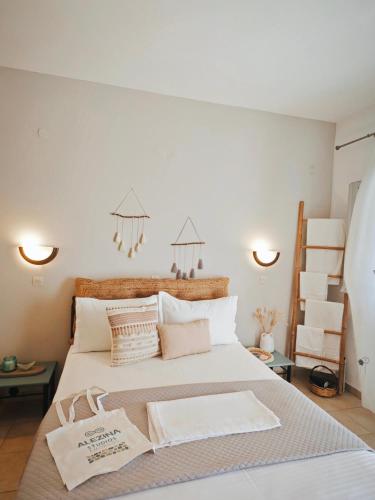 a bedroom with a large white bed with pillows at Alezina studios in Amorgos