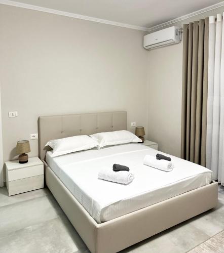 a white bedroom with a bed with towels on it at Vila Erti Berat in Berat