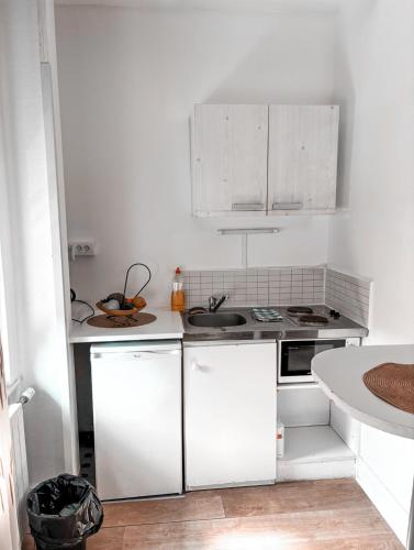 une cuisine blanche avec des armoires blanches et un évier dans l'établissement La ContrEscarpe - Studios fonctionnels - Secteur GARE CENTRE, à Amiens
