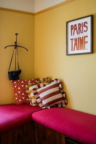 a room with a red couch and a sign on the wall at The London & Paris Hotel in Folkestone