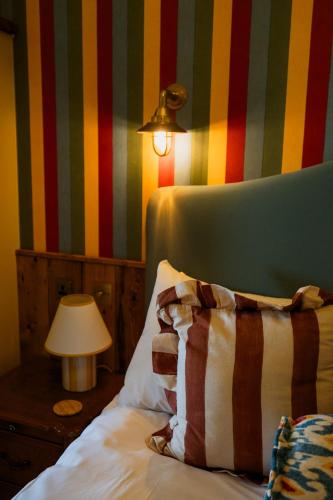 a bedroom with a bed with a striped wall at The London & Paris Hotel in Folkestone