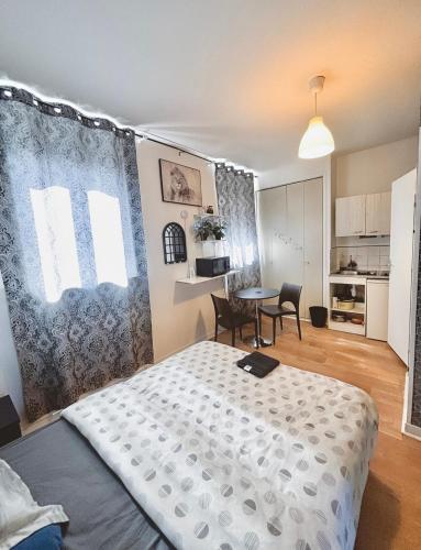 une chambre avec un lit et une table avec des chaises dans l'établissement La ContrEscarpe - Studios fonctionnels - Secteur GARE CENTRE, à Amiens