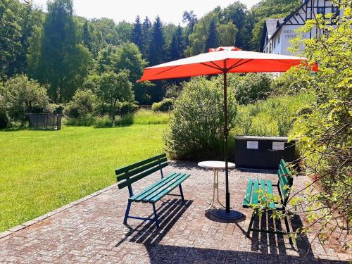 a picnic table with an umbrella and two chairs at Die Malche Gäste und Tagungshaus Villa App 13 in Alaunwerk