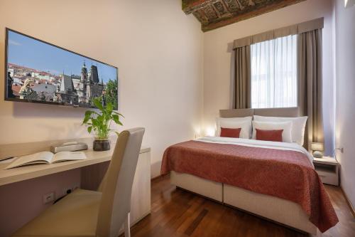 a hotel room with a bed and a desk and a television at Boutique Residence by Little King in Prague
