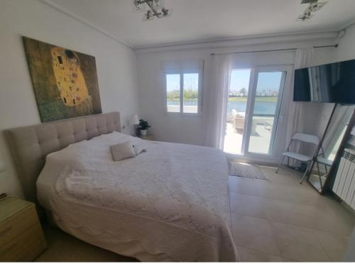 a bedroom with a large bed and a balcony at Beautiful views lake golf house in Roldán