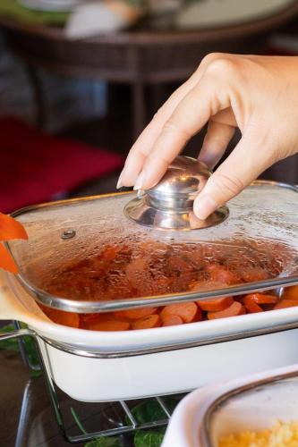 a person stirring a pot of food with a spoon at Pousada da Leide in Fernando de Noronha