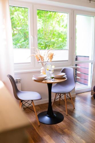 a table and chairs in a room with a window at Przytulny Apartament w centrum Rabki in Rabka