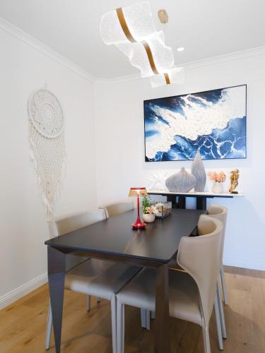a dining room with a black table and chairs at Chic Darling Harbour Oasis in the Heart of Sydney, 2BR 2BA, Resort-Style Amenities in Sydney